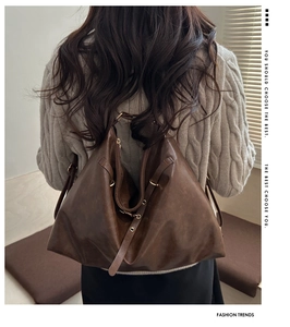 Detail of a large dark brown soft leather backpack worn by a model in casual city style