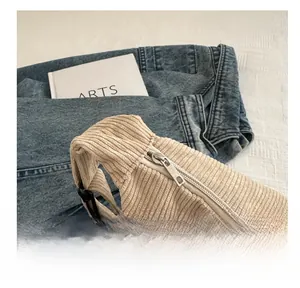 Detail of corduroy crossbody bag with smooth metal zipper and small round coin purse