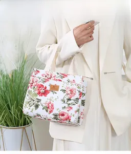 Detailed macro view of red rose floral pattern canvas bag with premium leather logo patch
