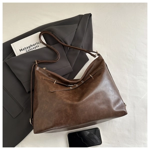 Flat lay of retro dark brown hobo bag with vintage texture and adjustable strap