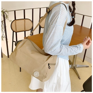 Detail of the adjustable shoulder strap and khaki nylon fabric on the crossbody bag