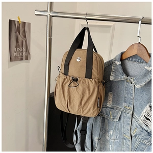 Detail of khaki nylon mini backpack with drawstring pocket and adjustable straps