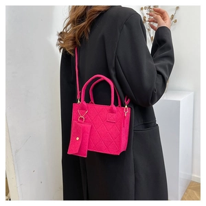 Detailansicht der fuchsiafarbenen Stepptasche aus Filz mit goldener Hardware und Etui