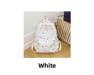 Detailed view of white canvas backpack featuring vibrant colorful star patterns and sturdy straps