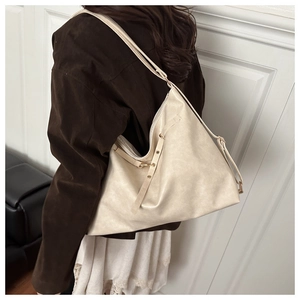 Detail showing high-capacity soft cream PU leather bag with decorative side lacing