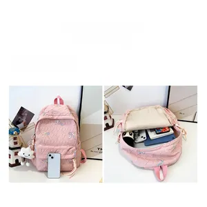 Pink quilted backpack with embroidered bows showing large capacity for tablets and books