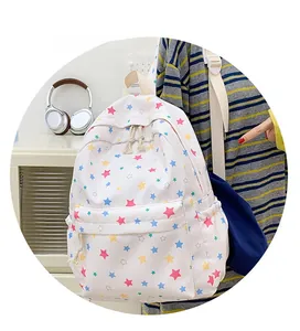 Detail of a white canvas backpack featuring a colorful star pattern and front pocket