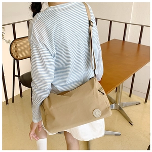 Detailed view of khaki large capacity nylon crossbody bag with adjustable shoulder strap