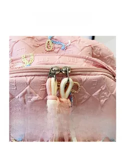 Detail view of the pink monogrammed backpack featuring durable dual metal zippers