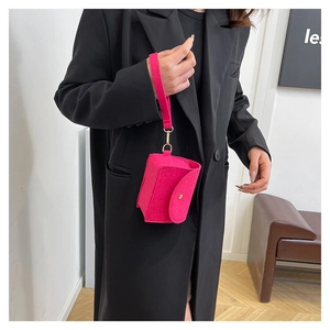 Makroaufnahme der rosaroten Filztasche mit goldenem Druckknopf und Handschlaufe