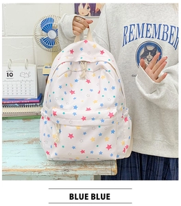 Close-up of white canvas backpack featuring colorful star patterns in a classroom setting