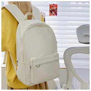 Close-up of cream canvas backpack featuring star and heart patterns and front zip pocket