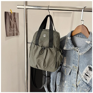 Army green water-resistant nylon backpack with drawstring pocket and top handles