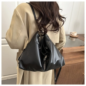 Macro detail of high-quality black faux leather tote with golden hardware accessories