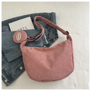 Detailed macro of pink corduroy crescent crossbody bag with small round coin purse