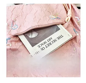 Close-up of front zipper pocket on pink striped backpack with animal embroidery detail