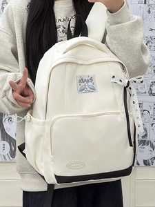 Detail of cream school backpack with polka dot ribbon and decorative patches