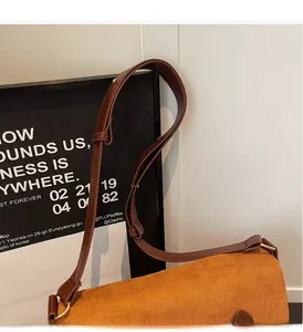 Detail of adjustable brown leather strap and orange corduroy texture of the tote bag