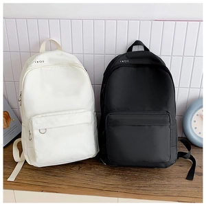 Detailed comparison of cream and black minimalist canvas backpacks with front zipper pockets