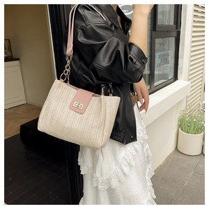 Close-up of pink leather trim and beige woven straw pattern on a beach tote bag