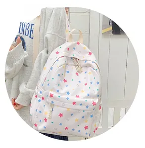 Close-up of a white canvas backpack featuring vibrant colorful star patterns and sturdy zippers