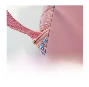 Macro shot of reinforced stitching and woven texture on pink striped backpack strap