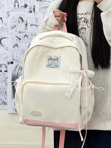 Detail view of canvas backpack with heart ribbon bows and angel wing embroidery