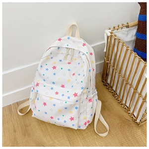 Detailed view of white canvas backpack featuring colorful star prints and cord zipper pulls