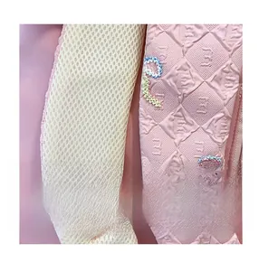 Detail of pink backpack featuring breathable mesh shoulder straps and rainbow embroidery