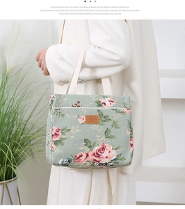 Detail of floral canvas lunch tote with pink roses, side zipper pocket and leather patch