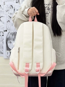 Detail view of cream and pink backpack featuring side drawstring pockets and back zip pocket