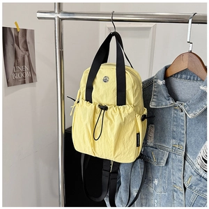 Detail view of lightweight yellow nylon backpack with drawstring pocket and LANWEIER brand tag
