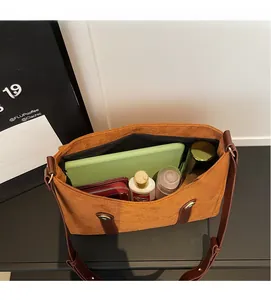 Spacious interior of brown faux suede tote bag holding tablet and accessories