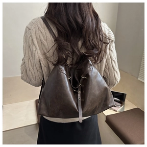 Detail of vintage brown leather backpack showing the premium texture and adjustable straps