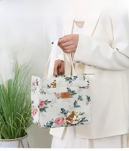 Detailed shot of canvas lunch tote bag featuring vintage rose floral patterns and top handles