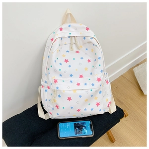 Detailed view of white canvas backpack featuring colorful star patterns and dual hemp rope zippers