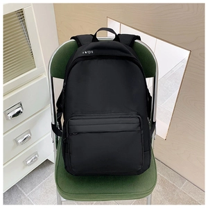 Detail of minimalist black canvas backpack with weather icons on green chair