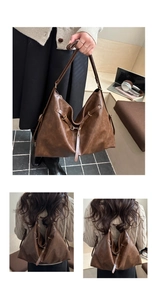 Detail view of large dark brown retro faux leather tote bag with stylish metal ring accents
