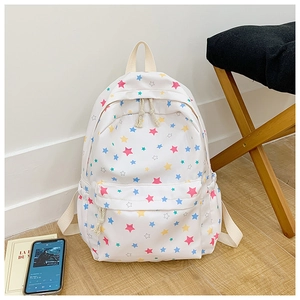 Detailed view of white canvas backpack with multi-color star prints and durable pockets