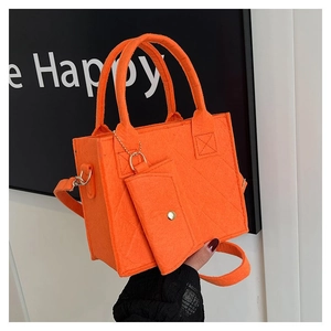 Detail der orangefarbenen Filzhandtasche mit Rautensteppung und abnehmbarem Gurt