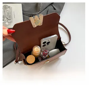 Détail de l'intérieur du sac tissé marron foncé montrant sa capacité de rangement