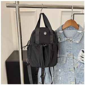 Detail of black nylon backpack with elastic drawstring pocket and dual top handles