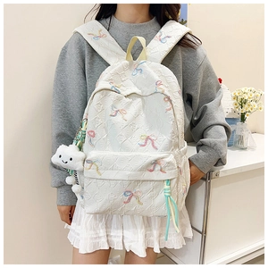 Detail of white striped backpack with colorful bow embroidery and quilted pattern