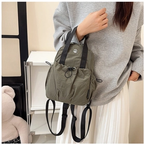 Detail of army green waterproof nylon backpack with drawstring pocket and top handle