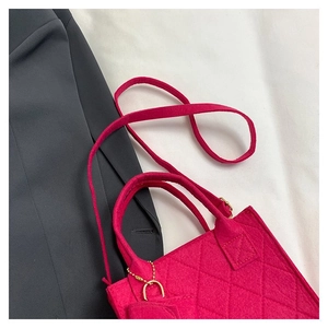 Detail der pinkfarbenen gesteppten Filzhandtasche mit Goldkette und abnehmbarem Gurt