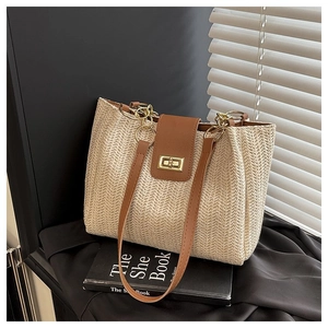 Detailed close-up of woven herringbone texture and brown leather strap on a tote bag