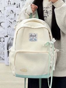 Close-up of cream and mint green school backpack with decorative lace ribbon and side pocket