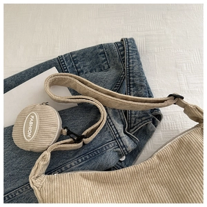 Detailed view of beige corduroy shoulder bag texture with small round fashion pouch