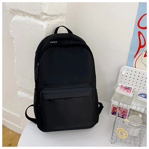 Detail view of the black minimalist canvas backpack featuring durable fabric and front pocket