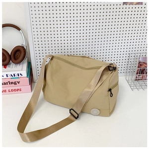 Close-up of khaki nylon shoulder bag with durable zipper pockets and adjustable strap